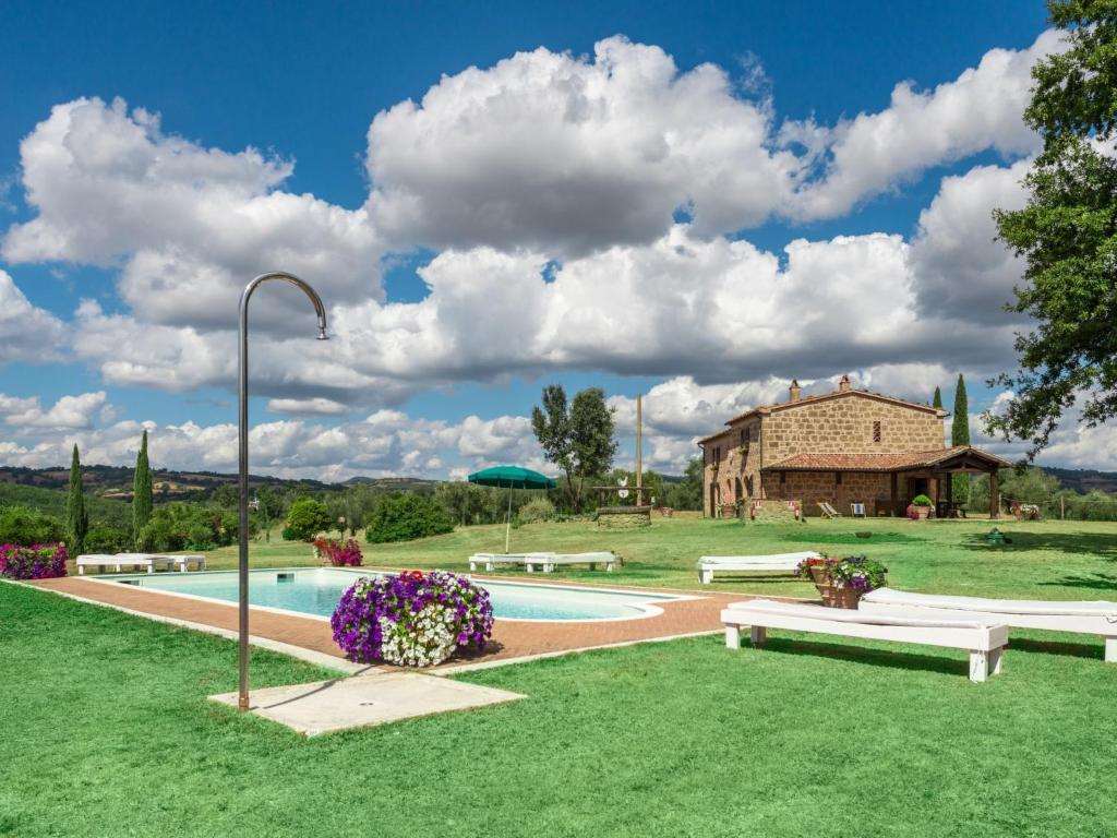 uma piscina com bancos e um edifício ao fundo em Holiday Home Casale Poggio Lupinaio by Interhome em San Martino