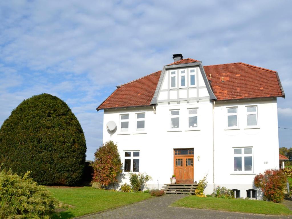 a white house with a red roof at Apartment Am Rotenberg by Interhome in Detmold