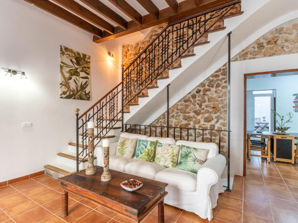 a living room with a white couch and stairs at Holiday Home Robin by Interhome in Sa Pobla