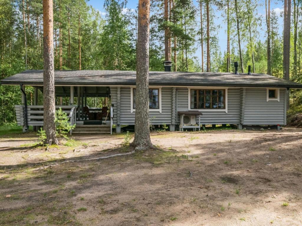 una casa blanca en el bosque con árboles en Holiday Home Mäntyranta by Interhome, en Savonranta
