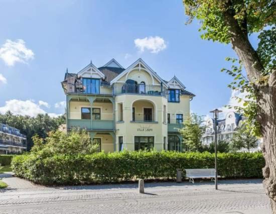 a large house with a bench in front of it at Appartmenthaus Villa Laura in Kühlungsborn