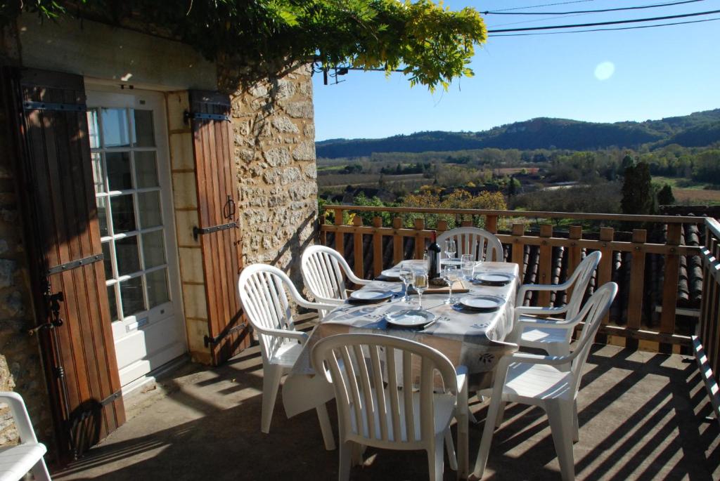 een tafel en stoelen op een balkon met uitzicht bij Maison Les Glycines in La Roque-Gageac