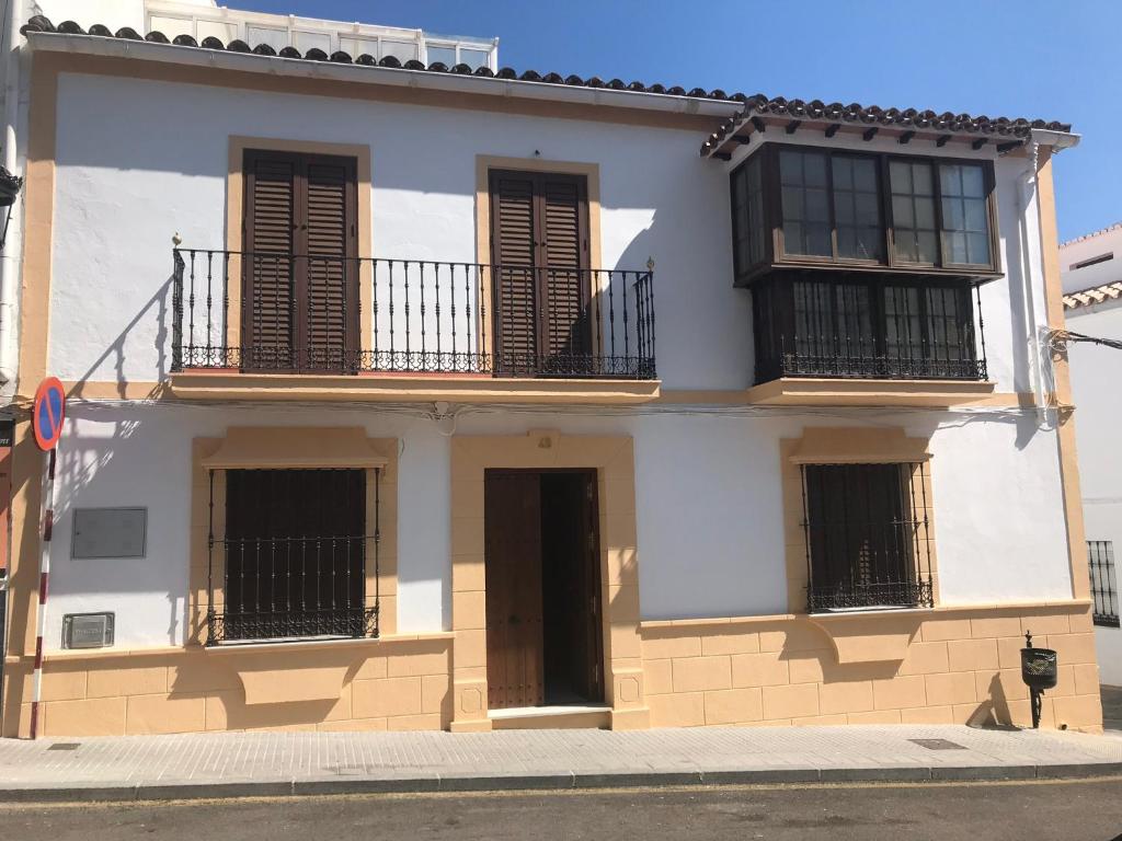 un edificio blanco con persianas marrones en Casa Los Molineros en Cortes de la Frontera