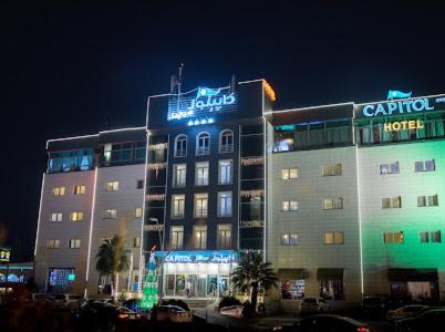 een gebouw met 's nachts een hotelbord bij Capitol Hotel in Erbil