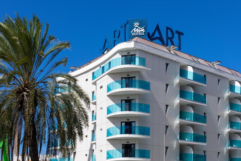 um edifício alto e branco com palmeiras em frente em ART Las Palmas em Las Palmas de Gran Canárias