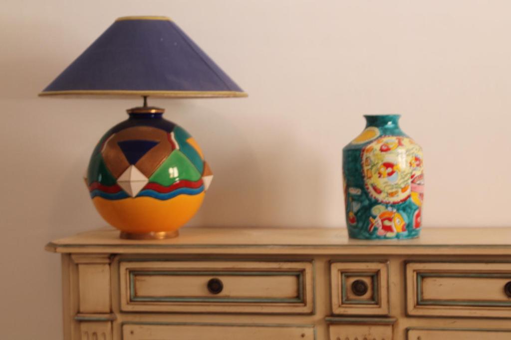 a lamp on a dresser with two vases on it at Mare E Timo in Marettimo