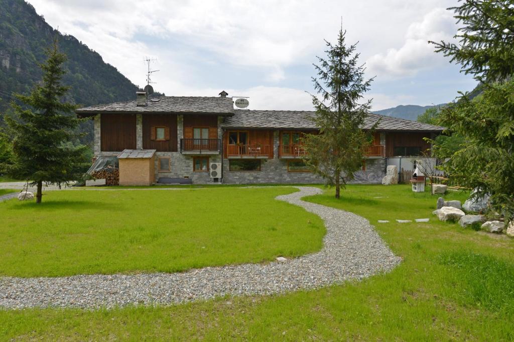 una casa con un patio de césped y una pasarela en Miravalle en Antey-Saint-André