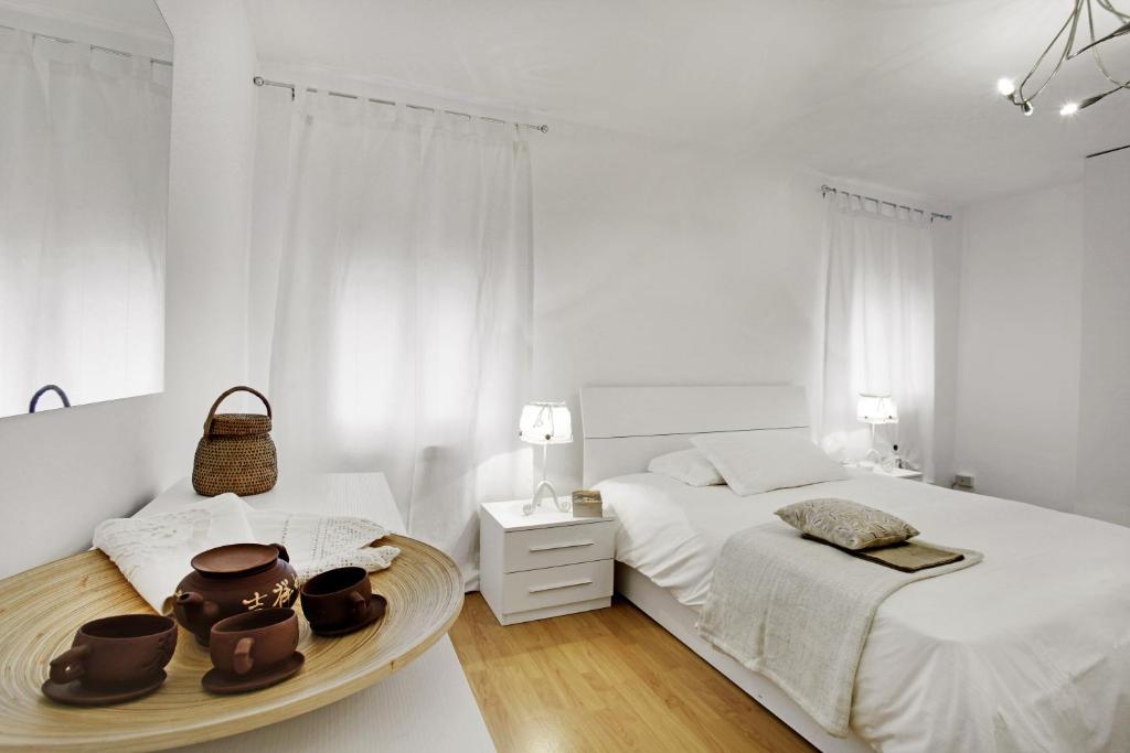 Un dormitorio blanco con 2 camas y una bandeja con sombreros. en La Casa Di Gemma & Regina Oriente, en Venecia