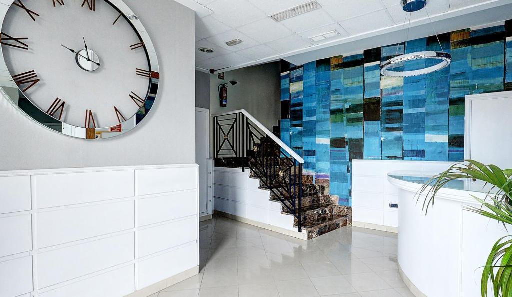 a large clock on the wall next to a staircase at Hotel Vila-real Azul in Villareal