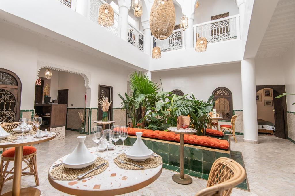 a room with tables and chairs and a couch at Riad Babouchta & Spa in Marrakech