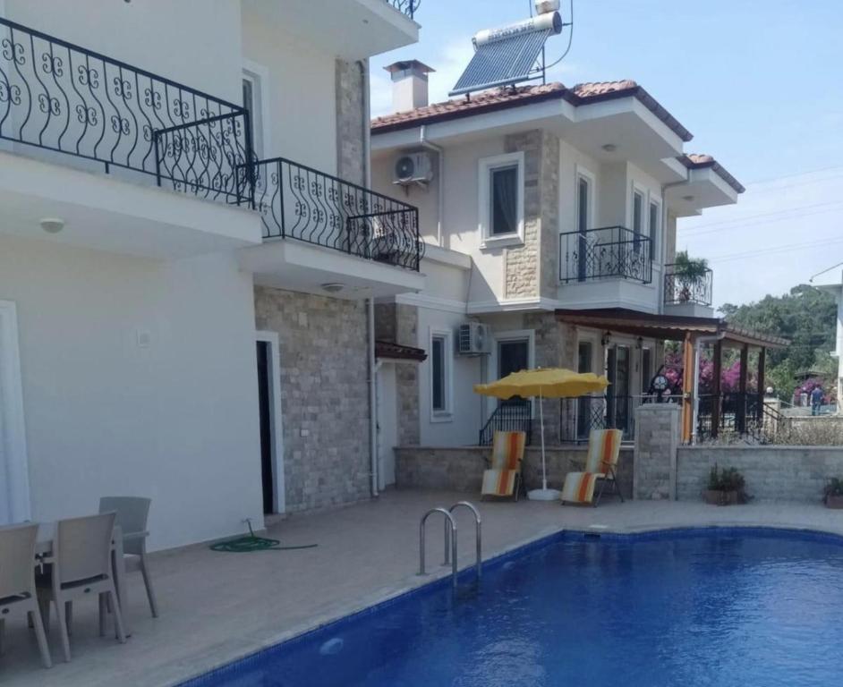 a villa with a swimming pool in front of a house at Fabulous 3 bedroom Apartment in Dalyan with pool in Dalyan
