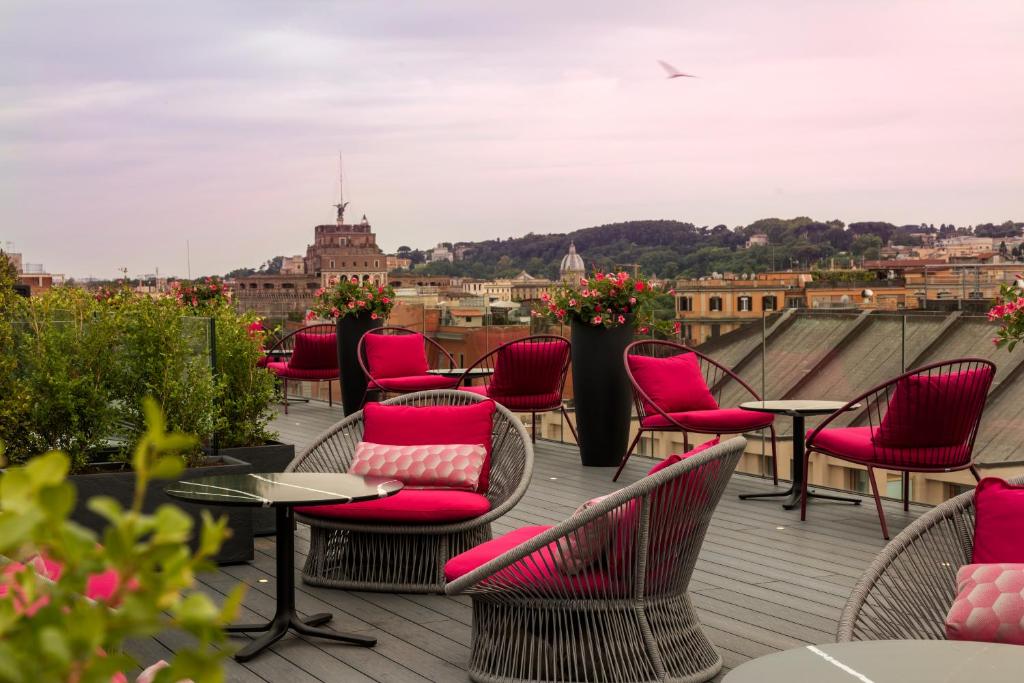 una terraza con sillas y mesas y vistas a la ciudad en Orazio Palace Hotel en Roma