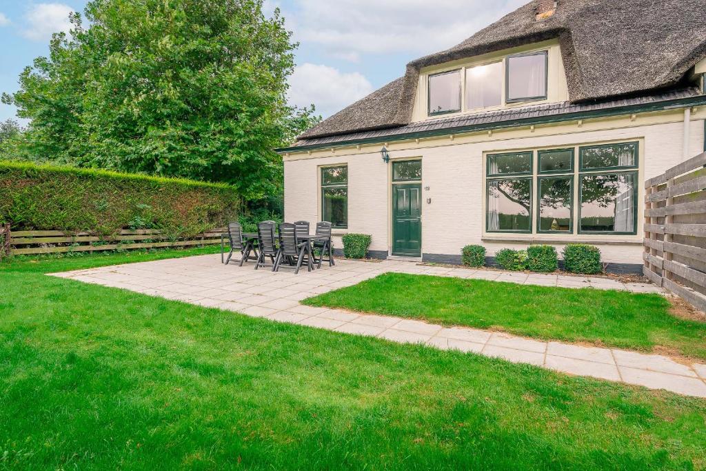 un patio con sillas y una mesa frente a una casa en Nieuwlanderweg 55, en De Waal