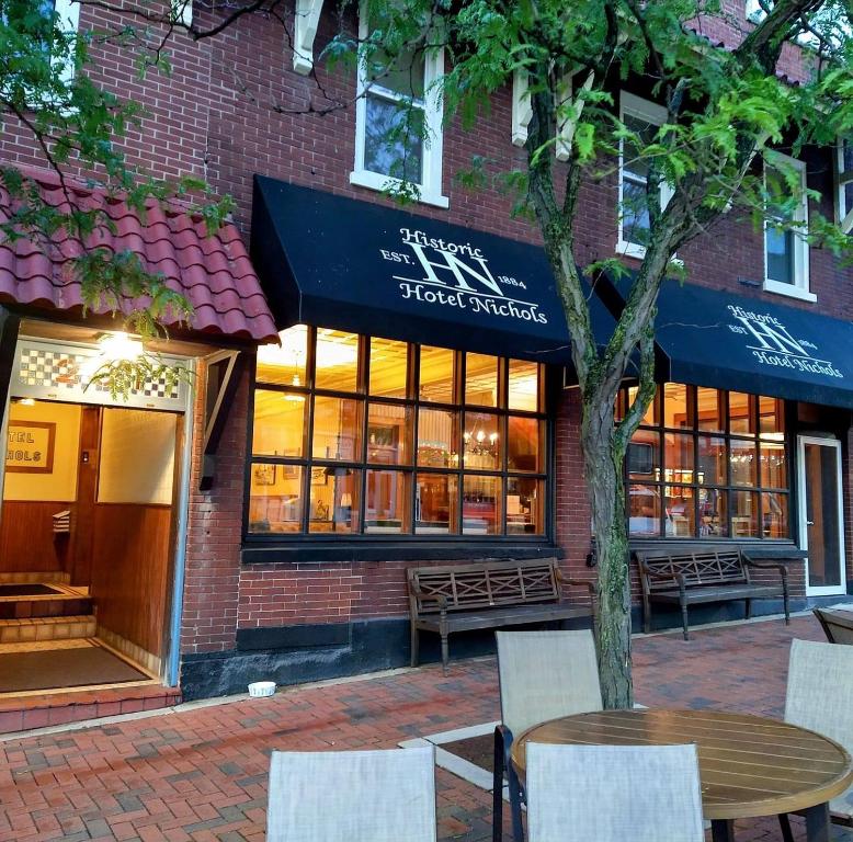 una tienda frente a un edificio de ladrillo con mesa y sillas en Historic Hotel Nichols, en South Haven