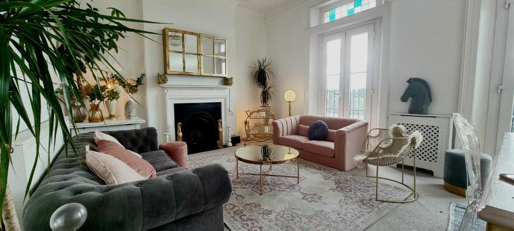 a living room with two couches and a fireplace at Elegant 5 bed 4 bath 'Vogue House' Parisian style home in Margate