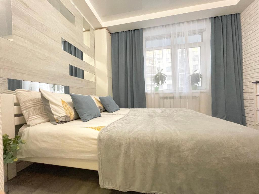 um quarto com uma grande cama branca com almofadas azuis em Apartment Studio New York 51 em Irpin