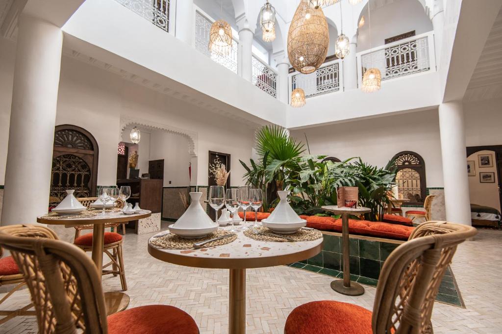 un restaurante con mesas y sillas y un sofá en Riad Babouchta & Spa, en Marrakech