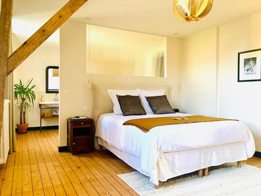 une chambre avec un grand lit et un parquet dans l'établissement LA MUSARDE, à Villers-sur-Mer