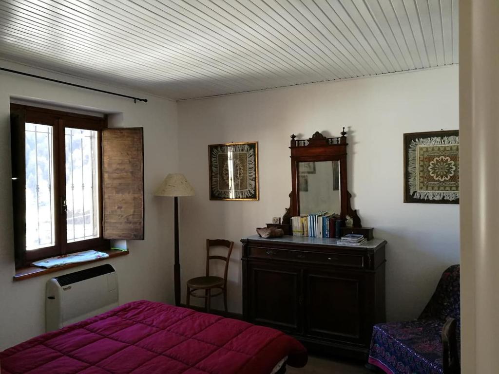 a bedroom with a bed and a dresser and a mirror at Appartamento a Fraisse. Natura e sport. A pochi minuti da Pragelato in Usseaux
