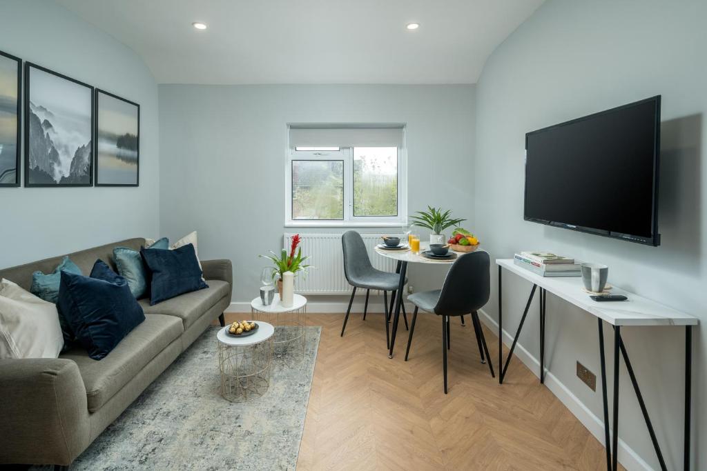 uma sala de estar com um sofá e uma mesa com uma televisão em Skyline Serviced Apartments - Flat B Rockingham Way em Stevenage