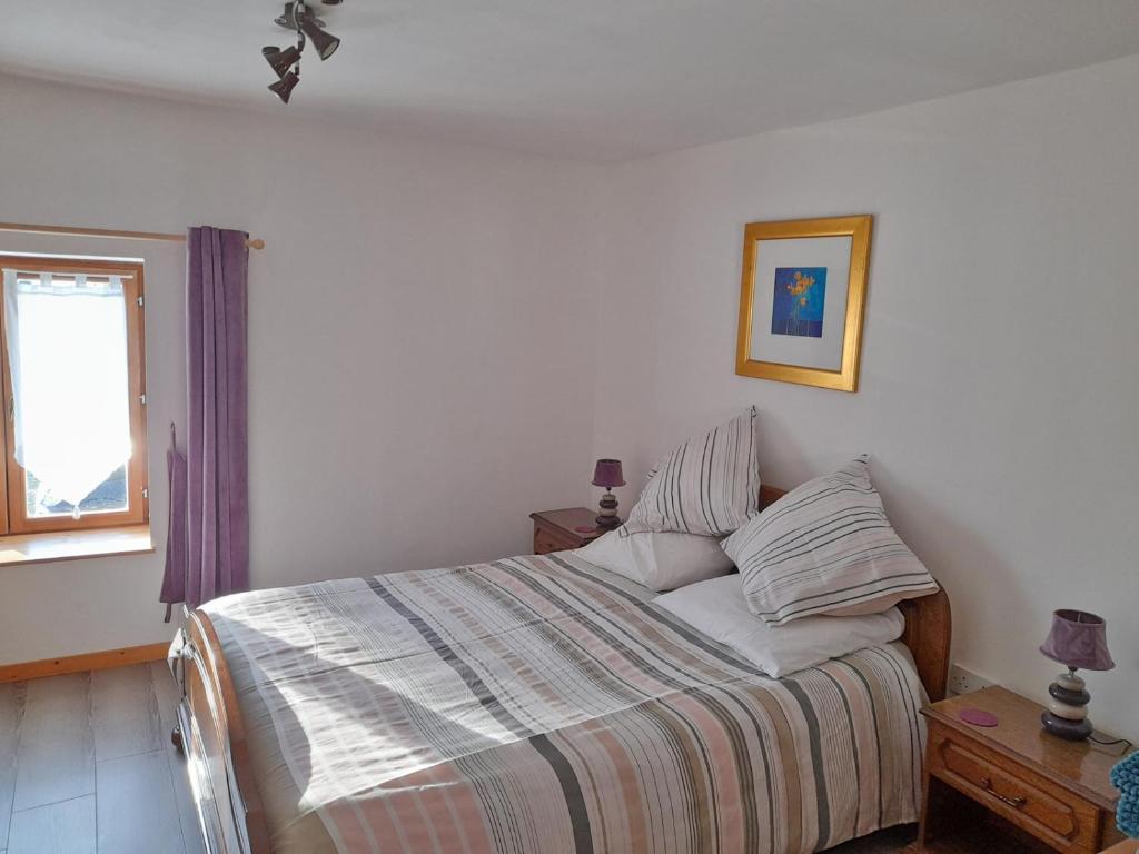 a bedroom with a bed and a window at Les Maricotais Gîte La Crécerelle in Trévérien