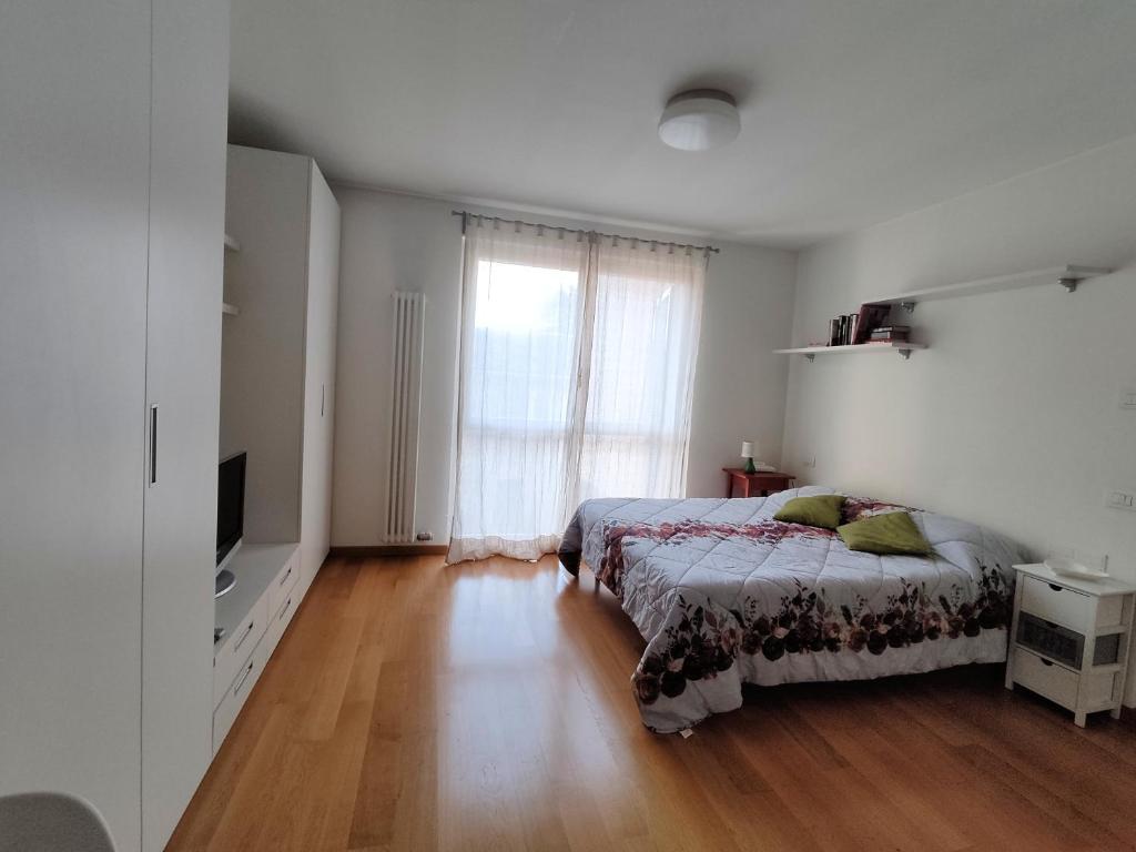 a bedroom with a bed and a large window at Soggiorno ai Portici in Vimercate