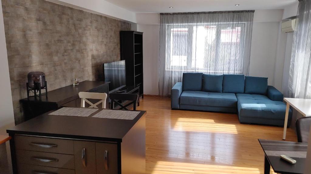 uma sala de estar com um sofá azul e uma mesa em Lemonhouse 2 em Bucareste