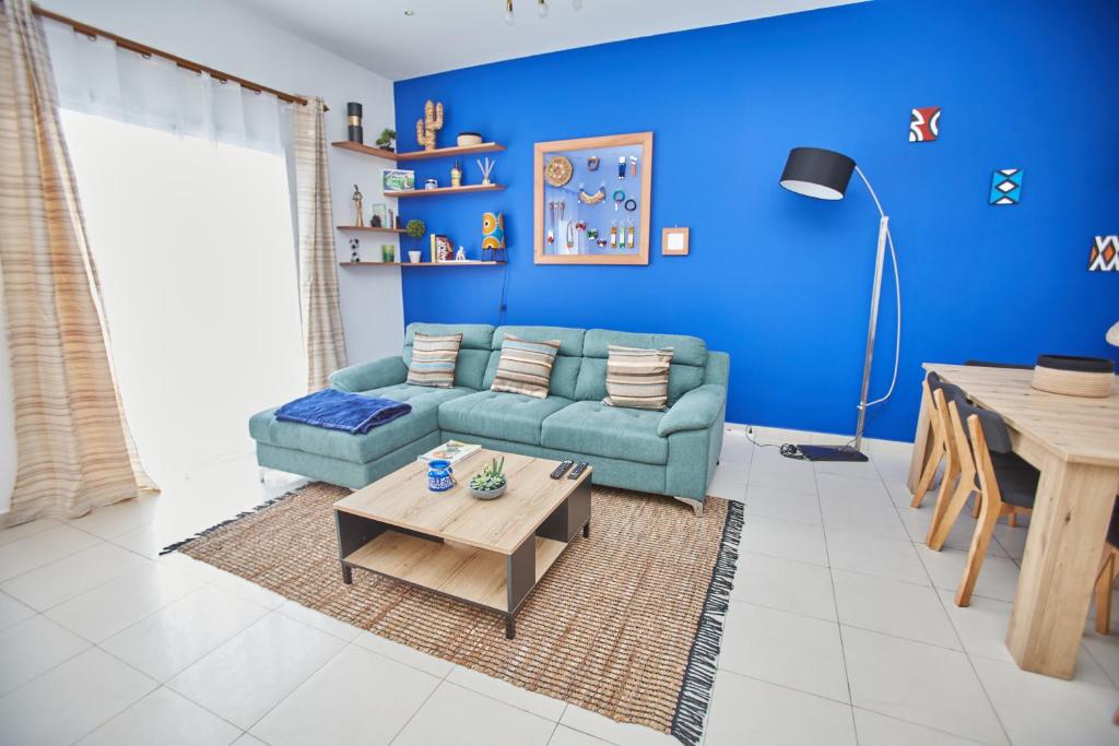 a blue living room with a couch and a table at Superbe vue sur océan in Pointe-Noire