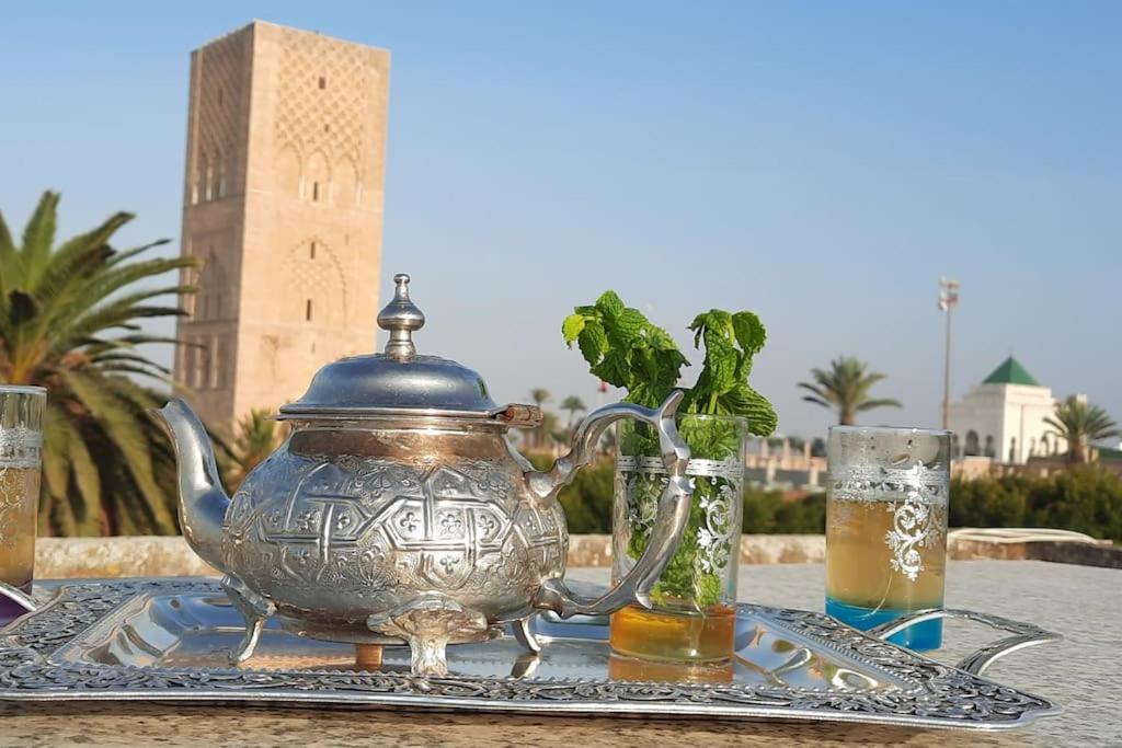 un tavolo con teiera e due bicchieri di birra di Hassan Tower and The Marina come to you a Rabat