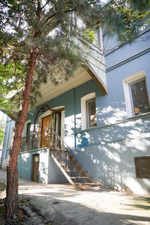 una casa blu con una scala accanto a un albero di chio's place a Tbilisi City
