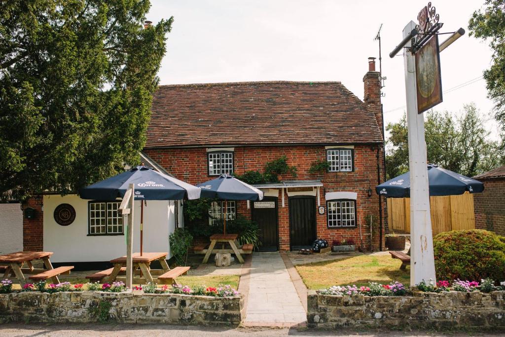 ein Haus mit zwei blauen Sonnenschirmen davor in der Unterkunft George and Dragon in Horsham