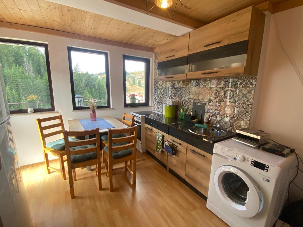 a kitchen with a washing machine and a table and chairs at Stoykite Escape House in Stoykite