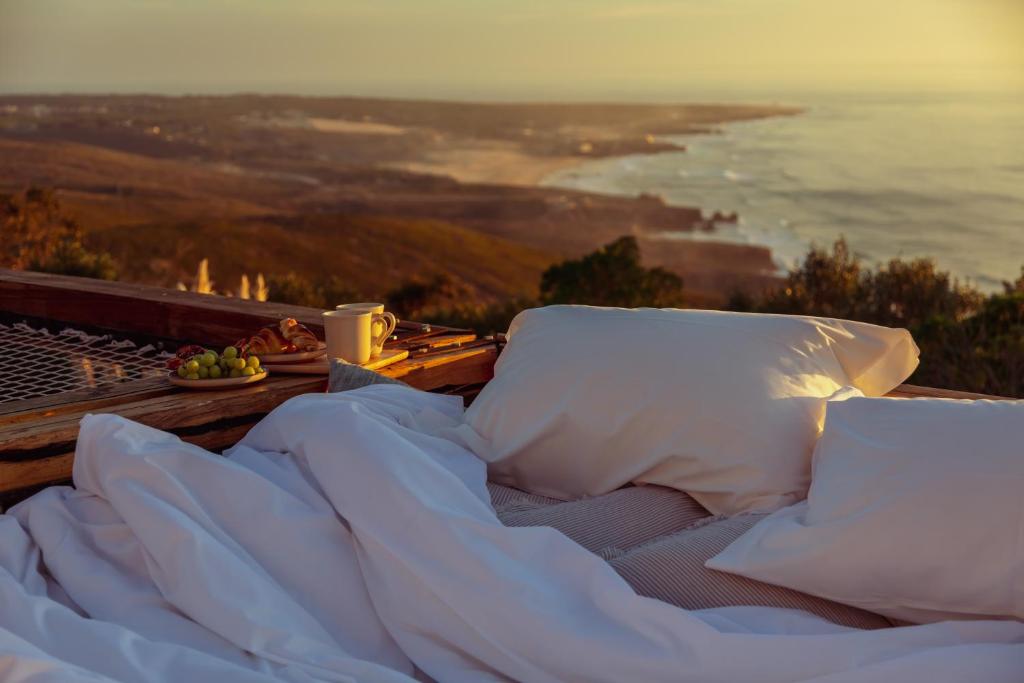 un letto con cuscini su un tavolo con vista sull'oceano di Wanted Nature House ad Azoia