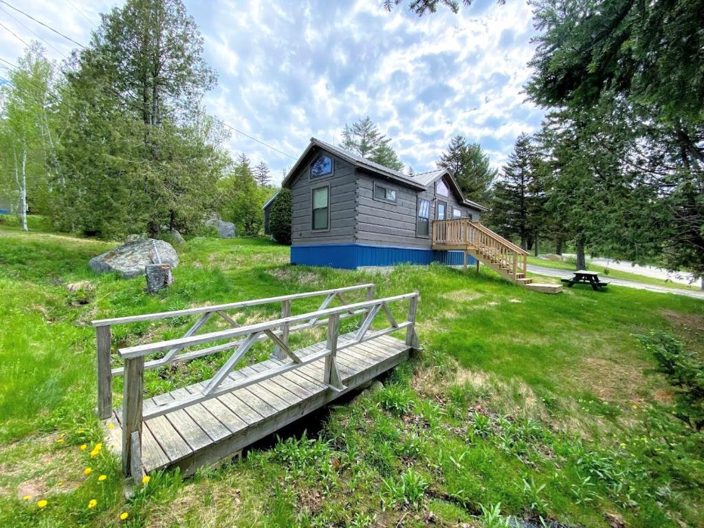 a small house in a field with a wooden bridge at B3 NEW Awesome Tiny Home with AC Mountain Views Minutes to Skiing Hiking Attractions in Carroll