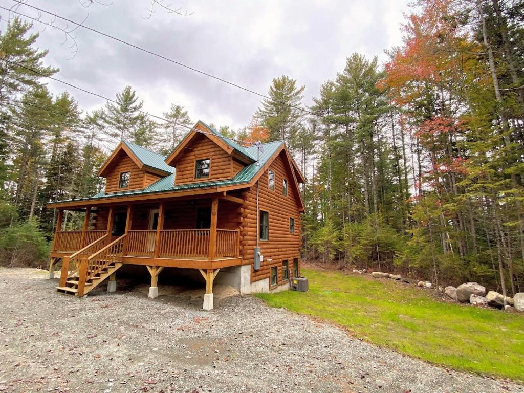 a large log cabin with a porch and a deck at Brand New Log Home Well appointed great location with AC wifi cable fireplace firepit in Bethlehem