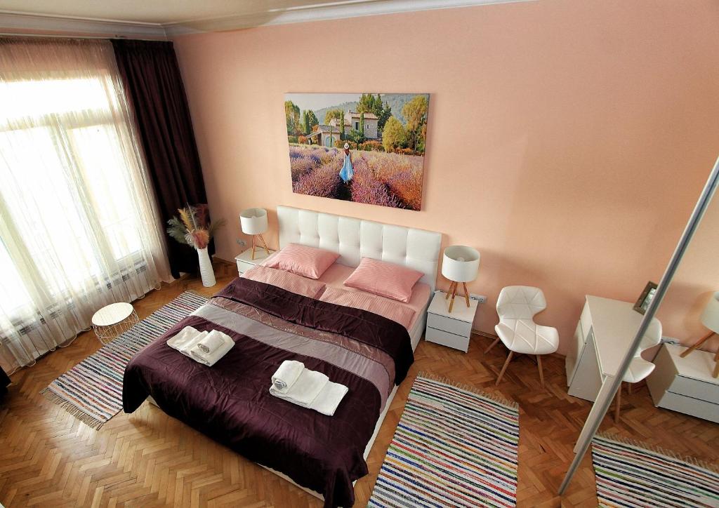 a bedroom with a bed and a painting on the wall at Colorful apartment in Sofia
