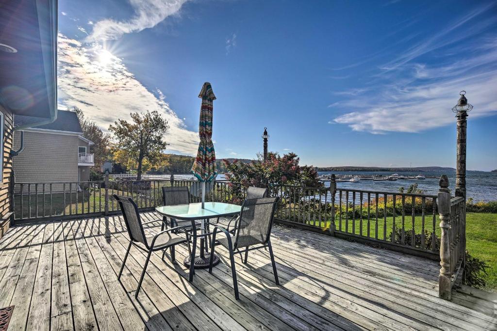 a patio with a table and chairs on a wooden deck at Waterfront Lake Champlain Home with Fire Pit! in Saint Albans Bay