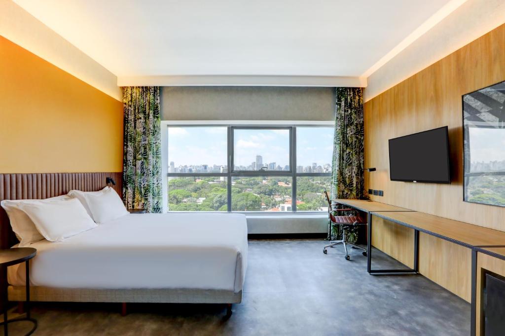 a hotel room with a bed and a television at Hilton Garden Inn Rebouças in Sao Paulo