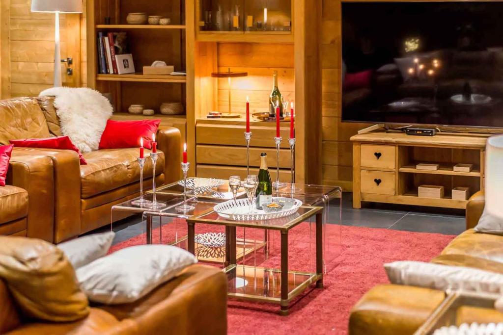 - un salon avec des canapés, une table et une télévision dans l'établissement Luxury apartment Stay With us Resorts, à Tignes
