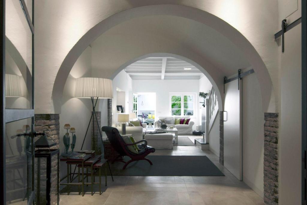 un arco que conduce a una sala de estar con sofá en La Casita del Mar, en Sitges