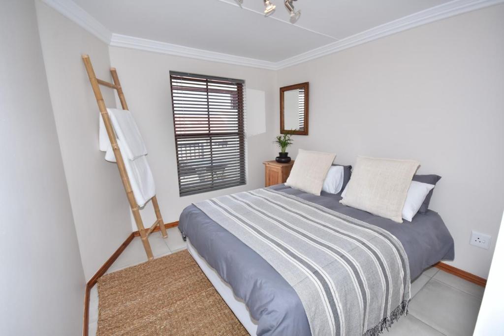 a bedroom with a bed and a window at Cyprus Manor 12 in Mossel Bay