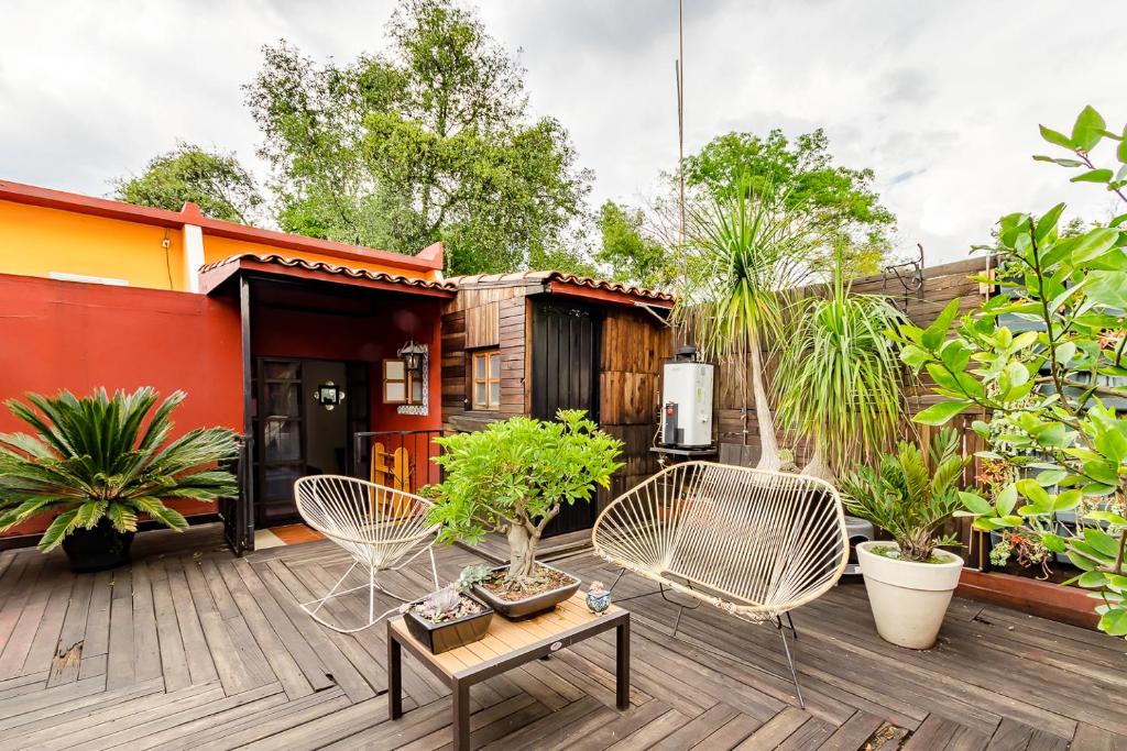 a deck with white chairs and a house at La Casita de Coyoacán in Mexico City