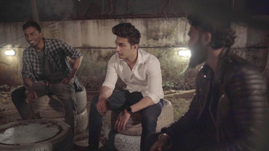 a group of three men sitting on old tires at Hostel Lifespace- Twin Bungalow with Pods, Bunks, Private Rooms, CoWork & Cafe in Pune