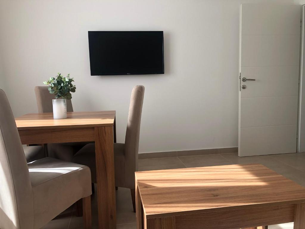a room with a table and a television on a wall at Apartmani Tesla in Soko Banja