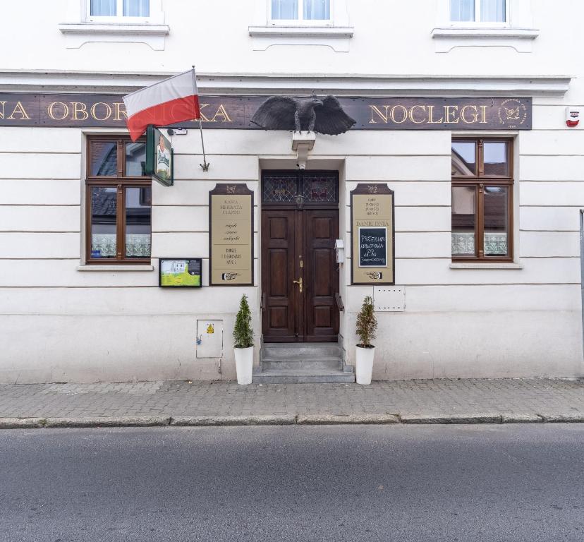 a building with a door and two plants in front of it at Kawerna Obornicka Pod Orłem Noclegi in Oborniki