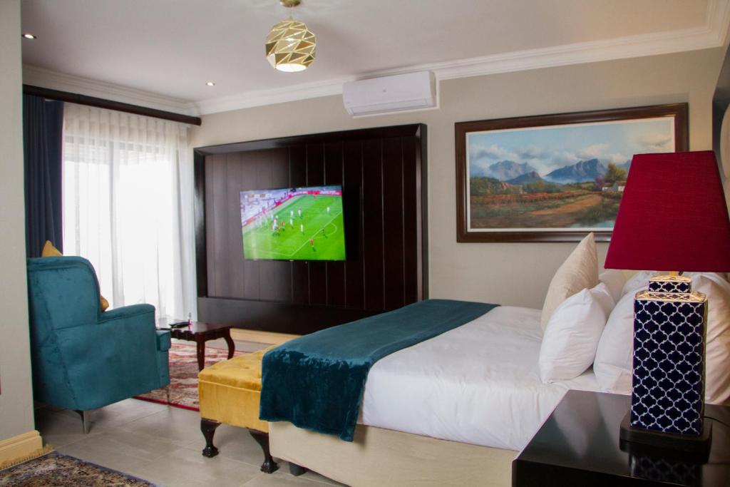 una camera con letto e TV a parete di Sasavona Boutique Hotel a Polokwane