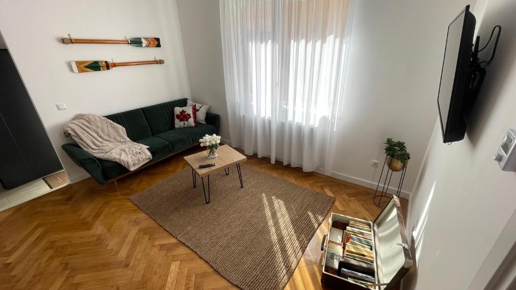 a living room with a green couch and a table at Maple Lodge in Braşov