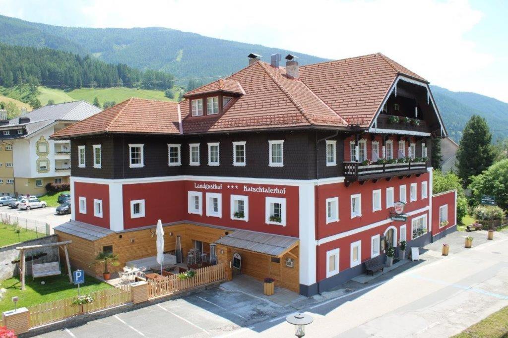 a large red building with a brown roof at Hotel-Landgasthof Katschtalerhof in Rennweg