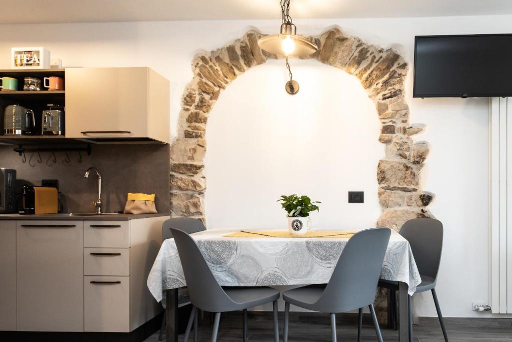 a kitchen with a table and chairs and a stone wall at Agritur E-Cinque in Salorno