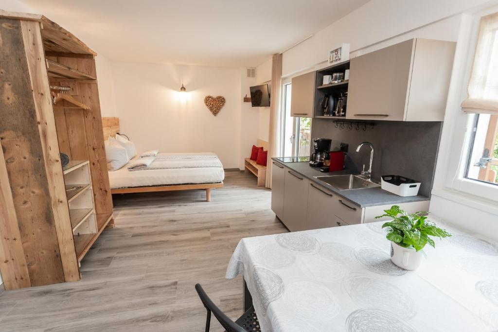 a kitchen with a table and a bed in a room at Agritur E-Cinque in Salorno